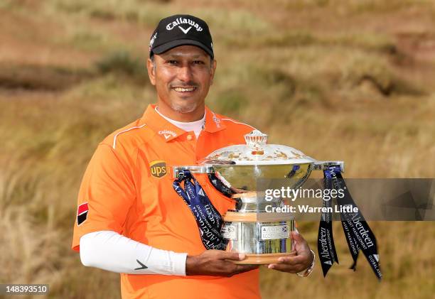 Jeev Milkha Singh of India poses with the trophy after winning a playoff against Francesco Molinari of Italy on the 18th green during the final round...