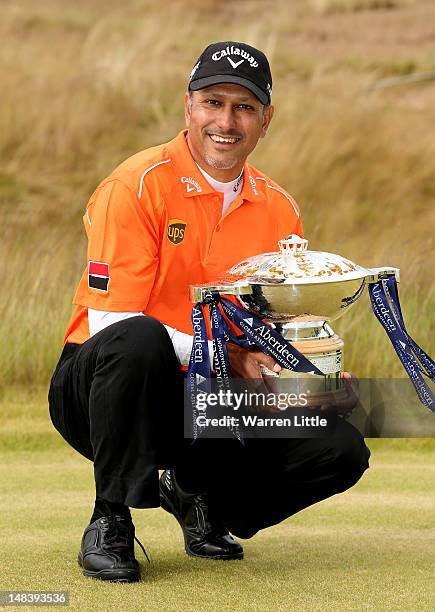 Jeev Milkha Singh of India poses with the trophy after winning a playoff against Francesco Molinari of Italy on the 18th green during the final round...