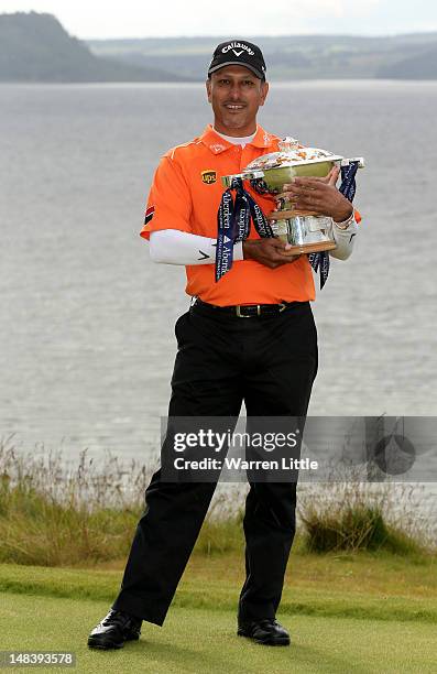 Jeev Milkha Singh of India poses with the trophy after winning a playoff against Francesco Molinari of Italy on the 18th green during the final round...