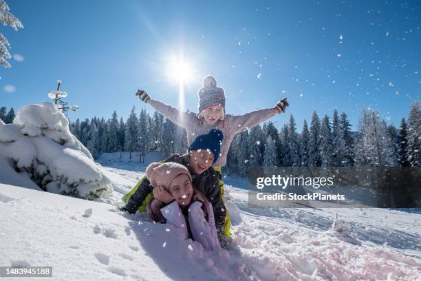 children are lying on top of each other in the snow - family skiing stock pictures, royalty-free photos & images
