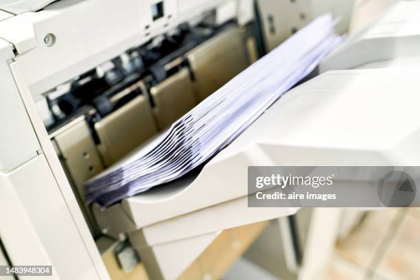 close up view of sheets of paper inside printer in the stationery store - stampatore foto e immagini stock