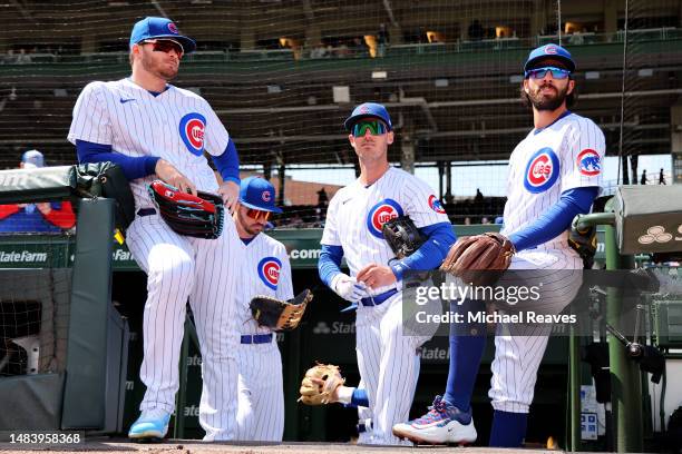 Ian Happ, Cody Bellinger and Dansby Swanson of the Chicago Cubs look on prior to the game against the Los Angeles Dodgers at Wrigley Field on April...