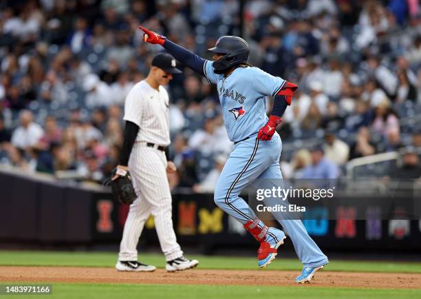 Vladimir Guerrero Jr. #27 of the Toronto Blue Jays celebrates as he rounds the bases after he hit a two run home run in the first inning as Anthony...