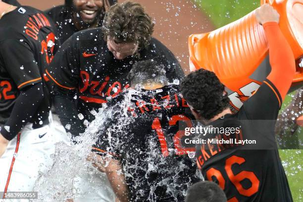 Adam Frazier of the Baltimore Orioles is dumped on with water after driving in the winning run in the ninth inning during a baseball game against the...