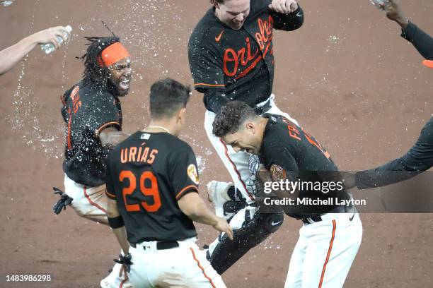 Adam Frazier of the Baltimore Orioles is sprayed with water after driving in the winning run in the ninth inning during a baseball game against the...