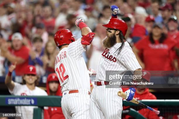 Kyle Schwarber and Brandon Marsh of the Philadelphia Phillies react following a home run by Schwarber during the seventh inning against the Colorado...