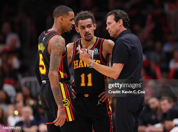Head coach Quin Snyder of the Atlanta Hawks converses with Trae Young and Dejounte Murray against the Boston Celtics during the fourth quarter of...