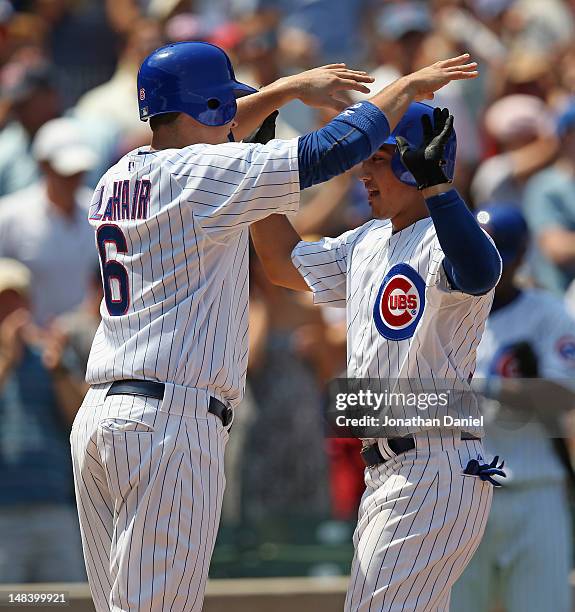 Darwin Barney of the Chicago Cubs is greeted by teammate Bryan LaHair after hitting a two-run home run in the 2nd inning against the Arizona...