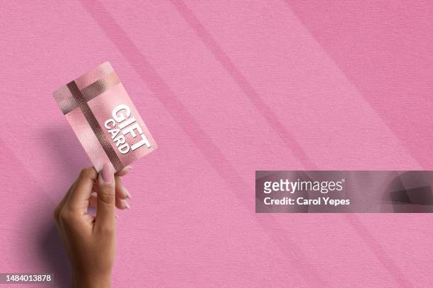 female hand holding a gift card - voucher card imagens e fotografias de stock