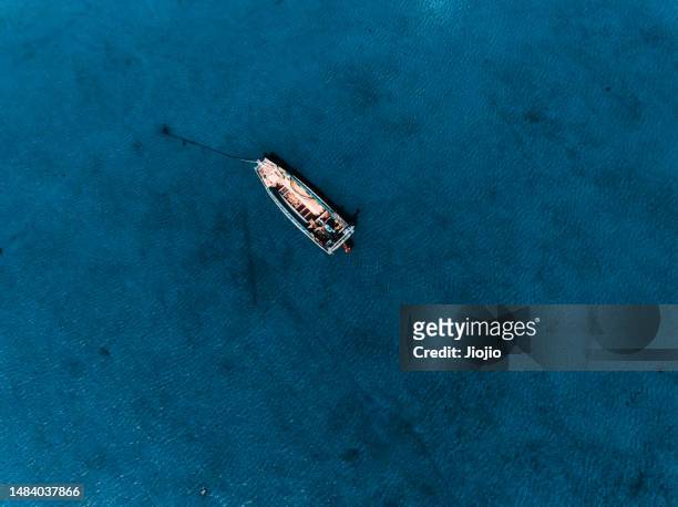 a fishing boat is stranded on low tide beach - anchored stock pictures, royalty-free photos & images
