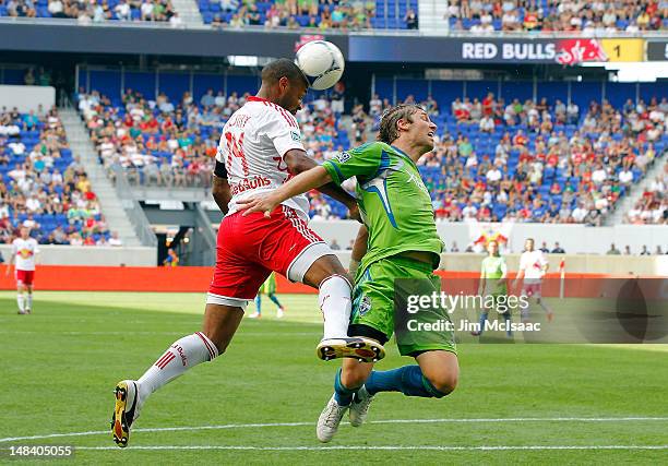 Thierry Henry of the New York Red Bulls heads the ball in the second half against Jeff Parke of the Seattle Sounders at Red Bull Arena on July 15,...