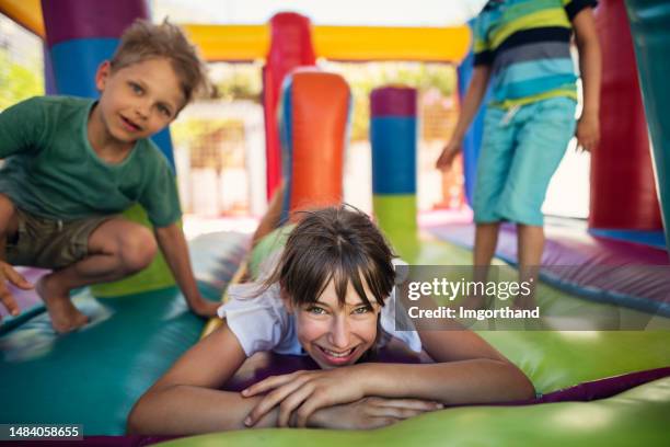 kids having extreme fun in inflatable bouncy castle playground - inflatable playground stock pictures, royalty-free photos & images