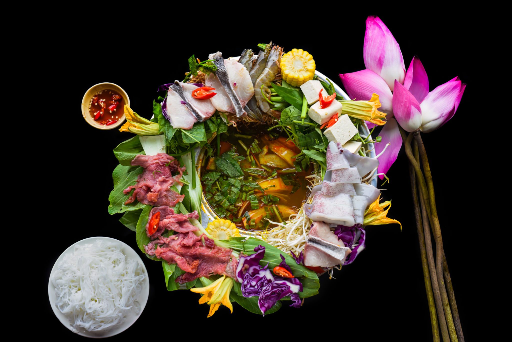Vietnamese hot pot with raw seafood on black background Vietnamese hot pot with raw seafood on black background