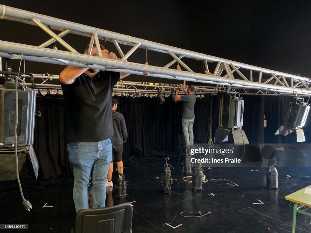 Lighting technician team installing spotlights on theater stage