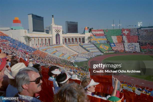 The Olympic Torch Tower as spectators participate in a 'card stunt' which displays the flags of all participating nations during the opening ceremony...