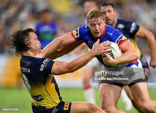 Lachlan Miller of the Knights is tackled by Reuben Cotter of the Cowboys during the round eight NRL match between North Queensland Cowboys and...