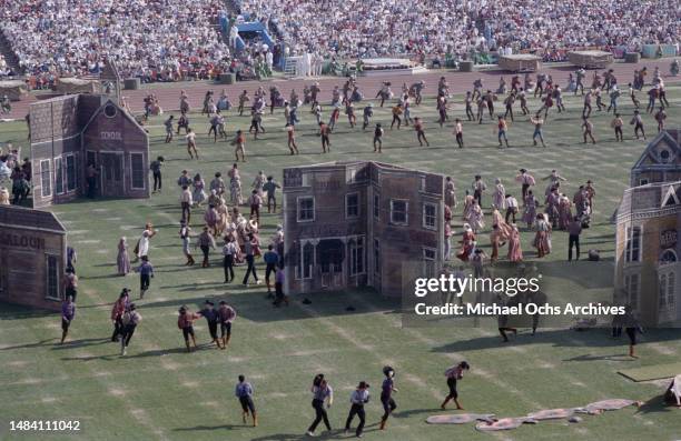 Performers during a hoedown dance amidst cutouts of an Old West town in the 'Pioneer Spirit' section of the 'Music of America' part of the opening...