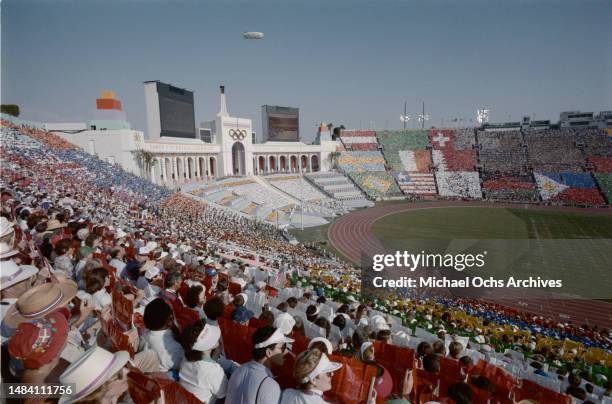 Spectators participate in a 'card stunt' which displays the flags of all participating nations during the opening ceremony of the 1984 Summer...