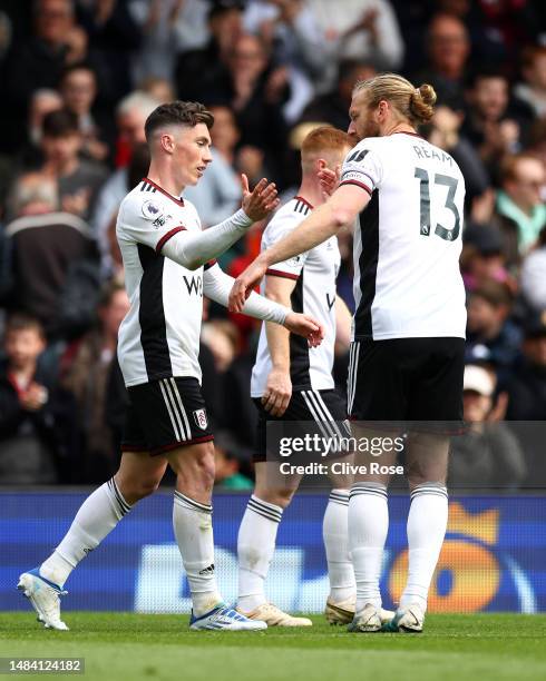 Harry Wilson of Fulham celebrates with teammate Tim Ream after scoring the team's first goal during the Premier League match between Fulham FC and...