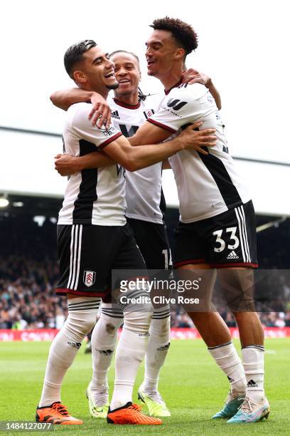 Andreas Pereira of Fulham celebrates with teammates Bobby Reid and Antonee Robinson after scoring the team's second goal during the Premier League...