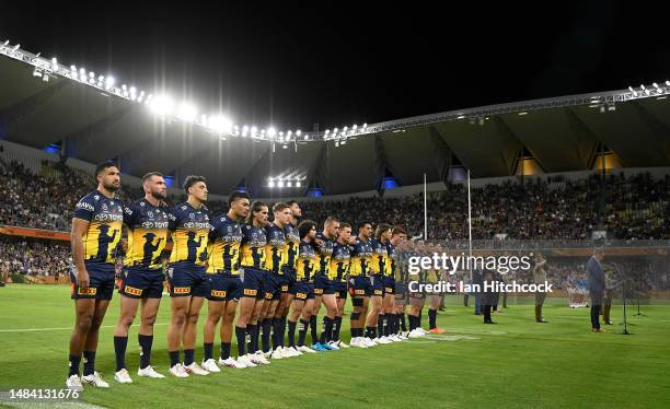 The Cowboy players line up for ANZAC Day commemorations prior to the round eight NRL match between North Queensland Cowboys and Newcastle Knights at...