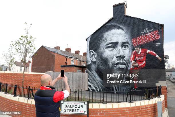 Fan takes a photo of a new mural of former Liverpool player, John Barnes, prior to the Premier League match between Liverpool FC and Nottingham...
