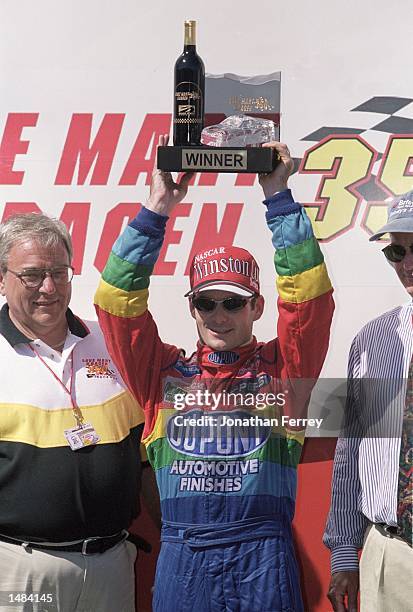 Jeff Gordon who drives for Hendrick Motorsports raises his trophy after winning the Save Mart/Kragen 350, part of the 2000 NASCAR Winston Cup Series...