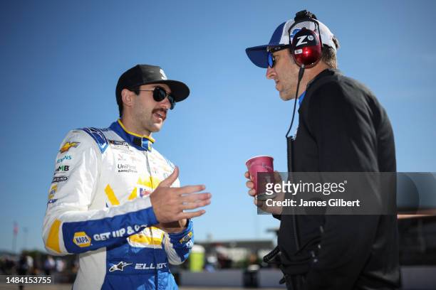 Chase Elliott, driver of the NAPA Auto Parts Chevrolet, and crew chief Alan Gustafson talk on the grid during qualifying for the NASCAR Cup Series...