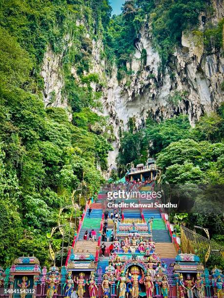 batu caves in kualalumpur on a clear blue summer day with pilgrims on stairs - batu caves stock pictures, royalty-free photos & images