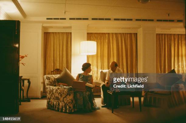 Queen Elizabeth II and her Private Secretary Sir Martin Charteris reviewing papers late at night on board HMY Britannia, 18th March 1972. Part of a...