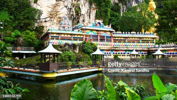 hindu temple and water pond outside batu caves entrance - batu caves stock pictures, royalty-free photos & images
