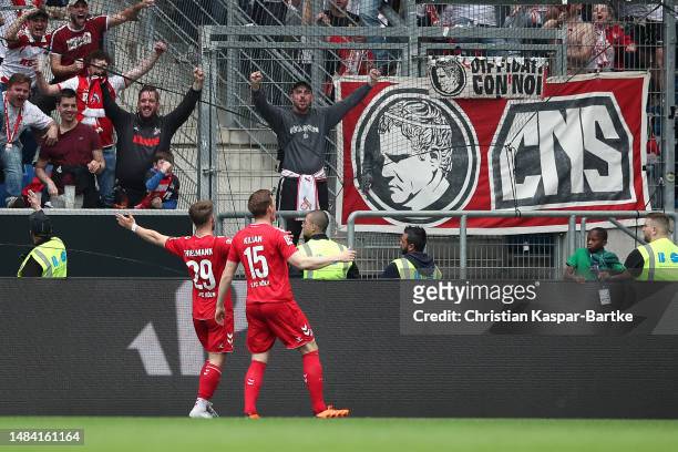 Jan Thielmann of 1.FC Koeln celebrates with teammate Luca Kilian after scoring the team's third goal during the Bundesliga match between TSG...