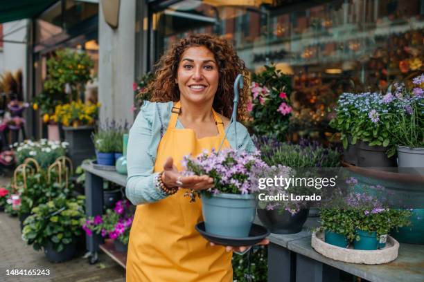 hermosa florista diversa trabajando en su floristería - cabeza de flor fotografías e imágenes de stock