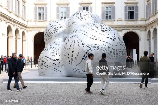 People walk around 'Objets Nomades' installation by Louis Vuitton