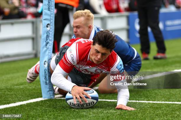 Louis Rees-Zammi of Gloucester Rugby touches down to score the team's first try whilst being tackled by Arron Reed of Sale Sharks during the...