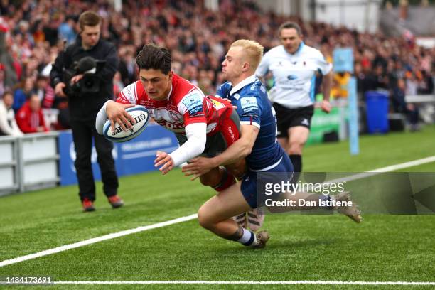 Louis Rees-Zammi of Gloucester Rugby touches down to score the team's first try whilst being tackled by Arron Reed of Sale Sharks during the...