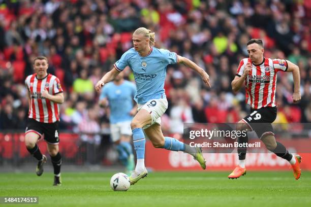 Erling Haaland of Manchester City runs with the ball from Jack Robinson of Sheffield United during the FA Cup Semi Final match between Manchester...