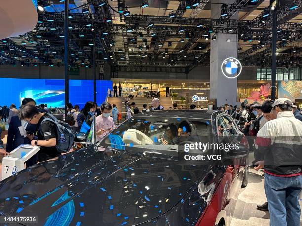 People visit the BMW booth during the 20th Shanghai International Automobile Industry Exhibition at the National Exhibition and Convention Center on...