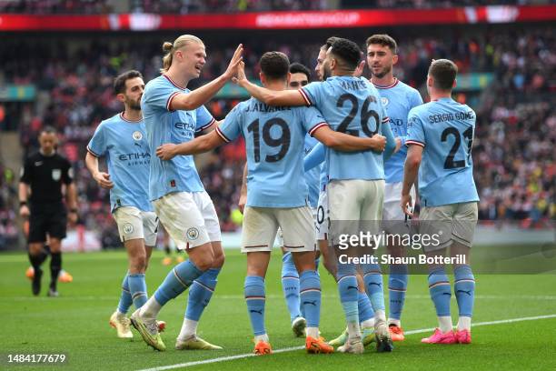 Riyad Mahrez of Manchester City celebrates with teammates after scoring the team's third goal and their Harrogate Town-trick during the FA Cup Semi...