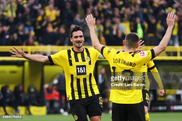 Mats Hummels of Borussia Dortmund celebrates with teammate Raphael Guerreiro after scoring the team's third goal during the Bundesliga match between...
