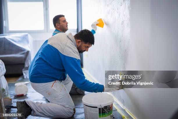 construction workers working on inside wall with paint brush and a spatula - decorating stock pictures, royalty-free photos & images