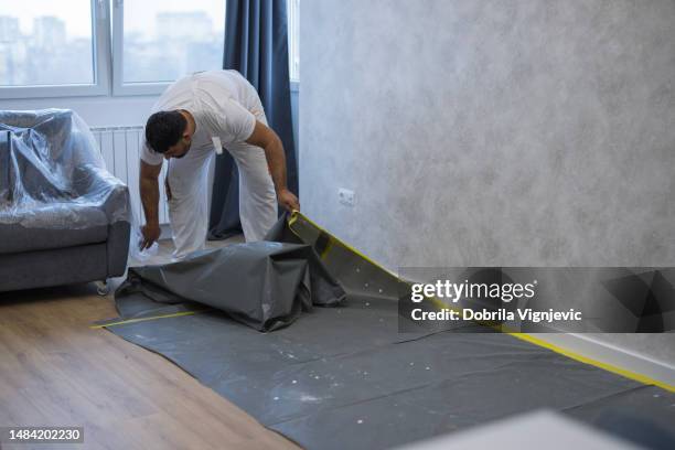 home painter removing protective nylon - remove barriers stock pictures, royalty-free photos & images