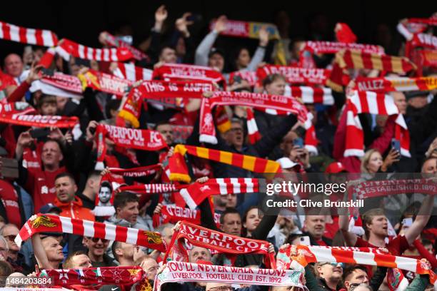 Liverpool fans hold their scarves during the Premier League match between Liverpool FC and Nottingham Forest at Anfield on April 22, 2023 in...