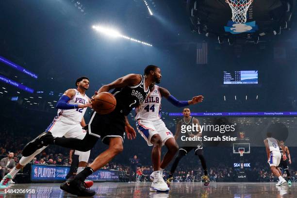 Mikal Bridges of the Brooklyn Nets dribbles as Tobias Harris and Paul Reed of the Philadelphia 76ers defend during the first half of Game Four of the...