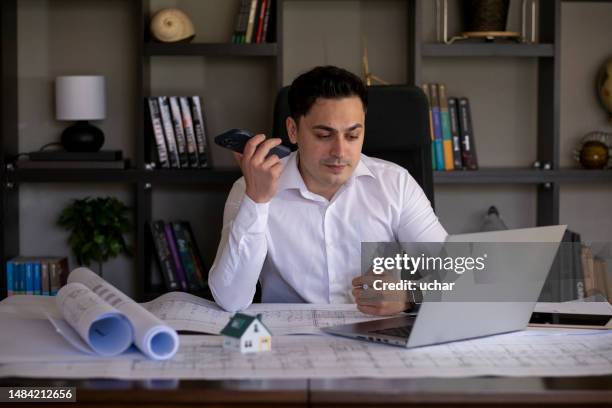 handsome young engineer talks about new housing project by teleconference - manage invest stock pictures, royalty-free photos & images