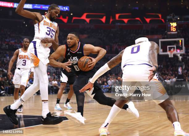Eric Gordon of the LA Clippers drives to the basket between Kevin Durant and Torrey Craig of the Phoenix Suns during the first quarter of Game Four...