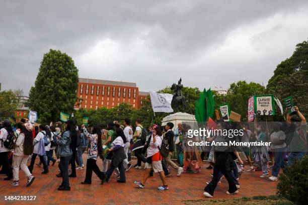 Activists participate in an Earth Day march titled “End the Era of Fossil Fuels,” through Lafayette Park near the White House on April 22, 2023 in...