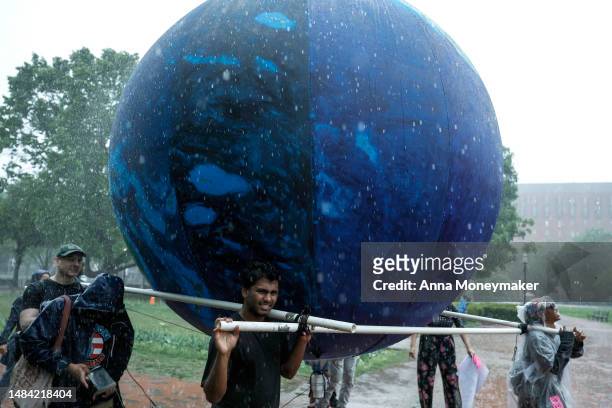 Activists participating in an Earth Day march titled “End the Era of Fossil Fuels,” carry an inflated replica of Earth out of Lafayette Park during a...
