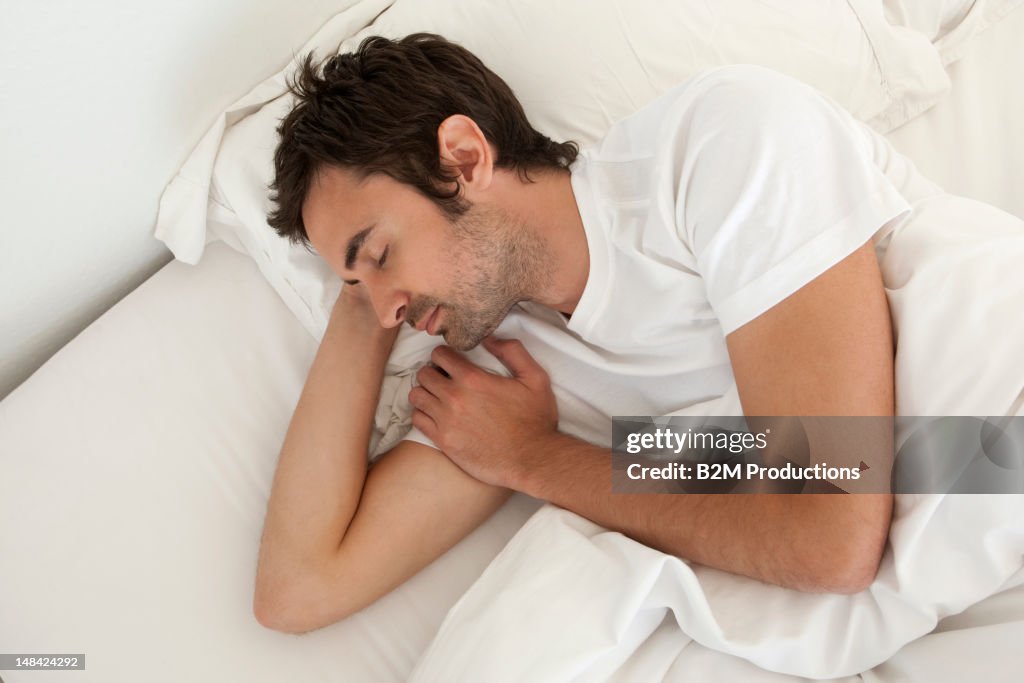 Young man asleep in bed