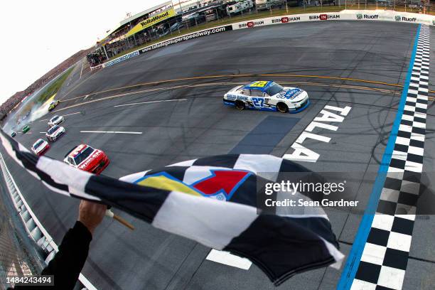 Jeb Burton, driver of the Solid Rock Carriers Chevrolet, takes the checkered flag to win the NASCAR Xfinity Series Ag-Pro 300 at Talladega...